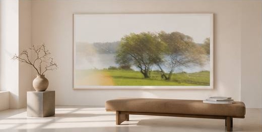 Fine art landscape in a minimalist room with a low upholstered pouf and vase